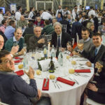 Festa di Natale 2015 Magazzino Allied International. Gruppo di persone sorridenti a tavola, calici e atmosfera festosa.