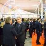 Festa di Natale 2016 Magazzino Allied International: folla elegante, luci festive e atmosfera conviviale.