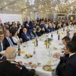 Festa di Natale 2017 Allied International: tavolo imbandito e persone sorridenti.