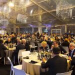 Festa di Natale 2019 Magazzino Allied International, sala piena, tavoli imbanditi, atmosfera festosa.