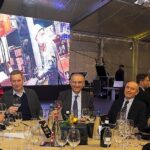 Festa di Natale 2019 Magazzino Allied International: gruppo di persone a tavola, brindisi e atmosfera conviviale.