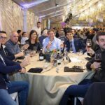 Foto di gruppo al Christmas Party 2019 Magazzino Allied International. Persone sorridenti con bicchieri di vino.