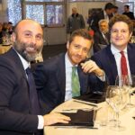 Foto di gruppo alla Christmas Party 2019 - Magazzino Allied International. Uomini in abito sorridono.