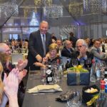Festa di Natale 2019 Magazzino Allied International: persone applaudono, atmosfera festosa.