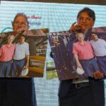 Festa di Natale 2019 Magazzino Allied International: due uomini mostrano foto in magazzino.