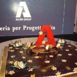 Torta celebrativa per Christmas Party 2019 Allied International con logo 'A' e decorazioni festive.